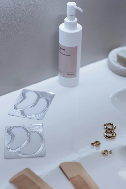 a white sink sitting under a mirror next to a pair of scissors, inspired by Alfred Jensen, purism, neck rings, product display, soft opalescent membranes, rose gold