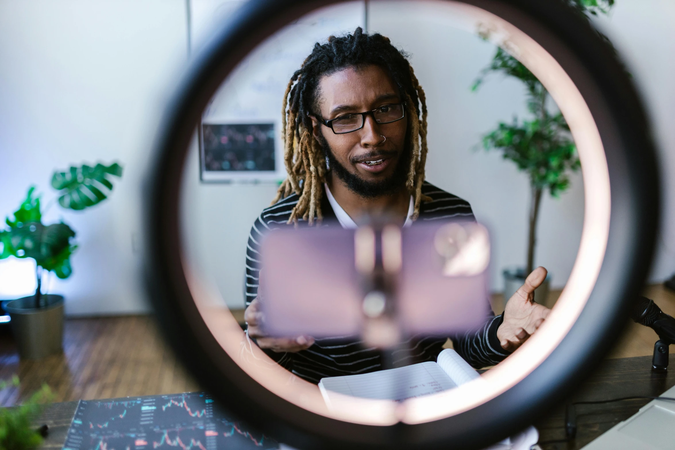 a man with dreadlocks looking through a magnifying lens, a hologram, by Washington Allston, pexels contest winner, kinetic art, studying in a brightly lit room, ring light, engineer, 🦑 design