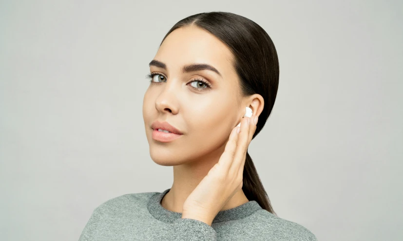 a woman holding her hand to her ear, trending on pexels, photoshoot for skincare brand, portrait sophie mudd, earbuds, product view