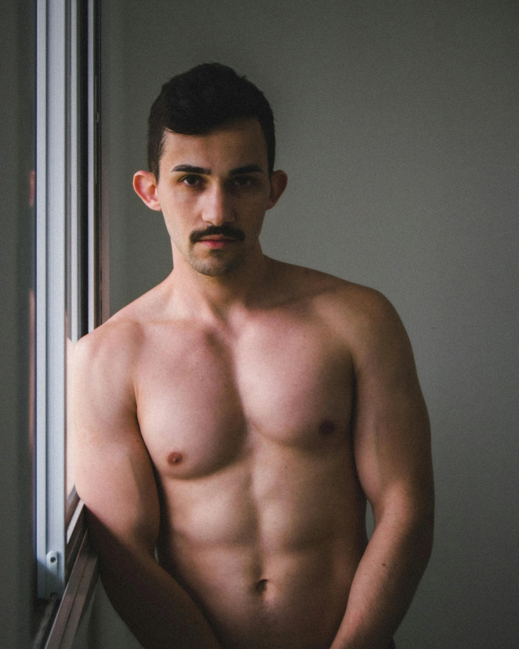 a shirtless man standing in front of a window, by Adam Dario Keel, mexican mustache, nonbinary model, gif, trending photo