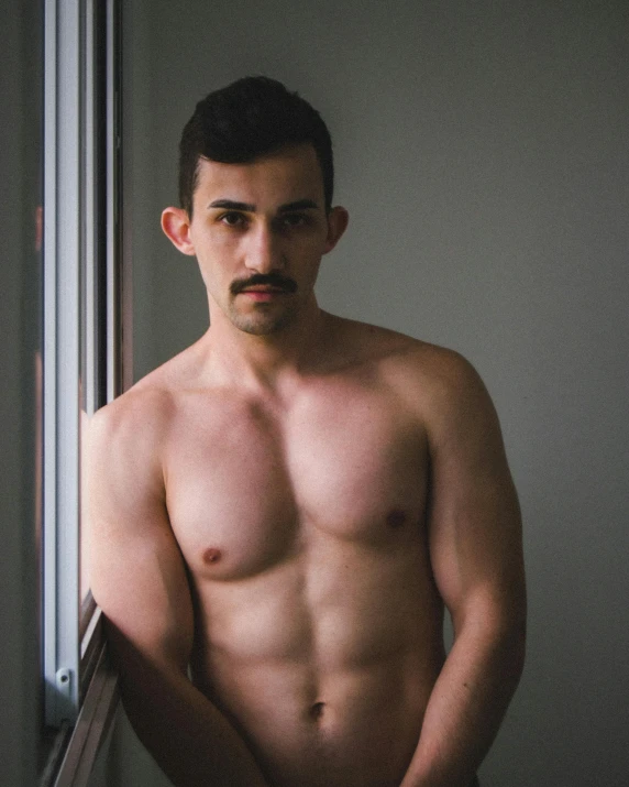 a shirtless man standing in front of a window, by Adam Dario Keel, mexican mustache, nonbinary model, gif, trending photo