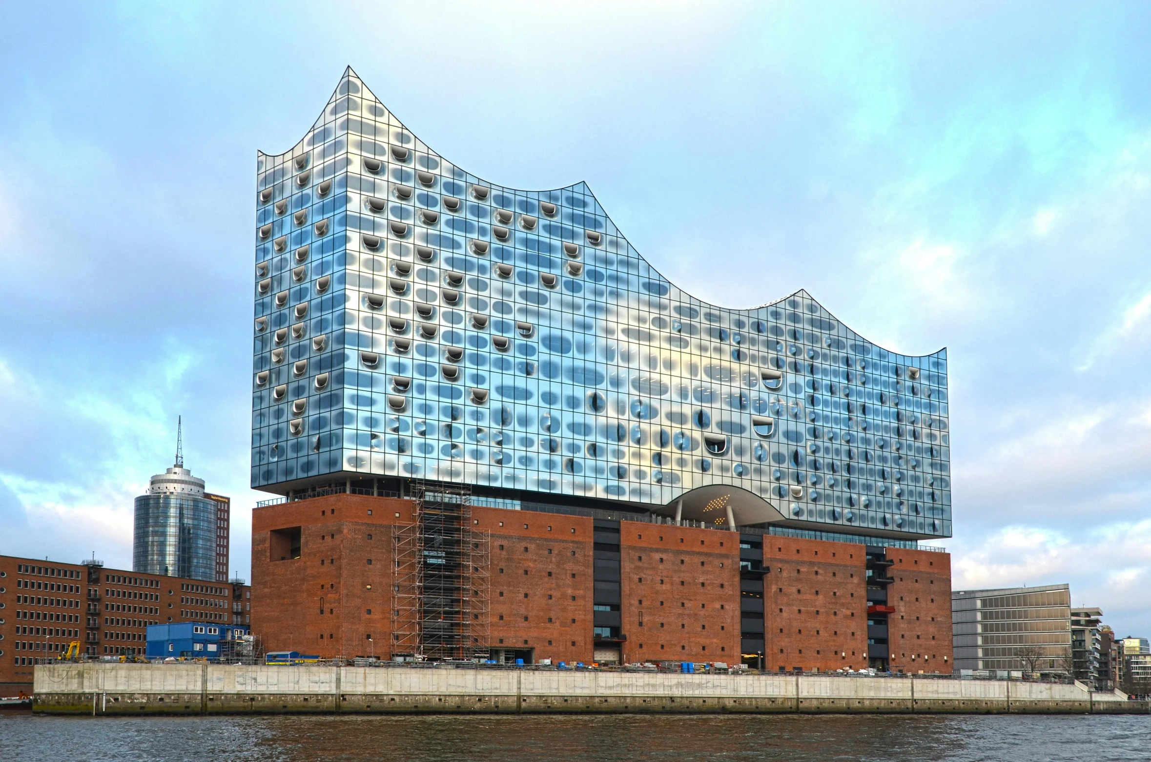 a large building sitting next to a body of water, inspired by Victor Enrich, pexels contest winner, modernism, germany, tesselation, glass buildings, three - quarter view