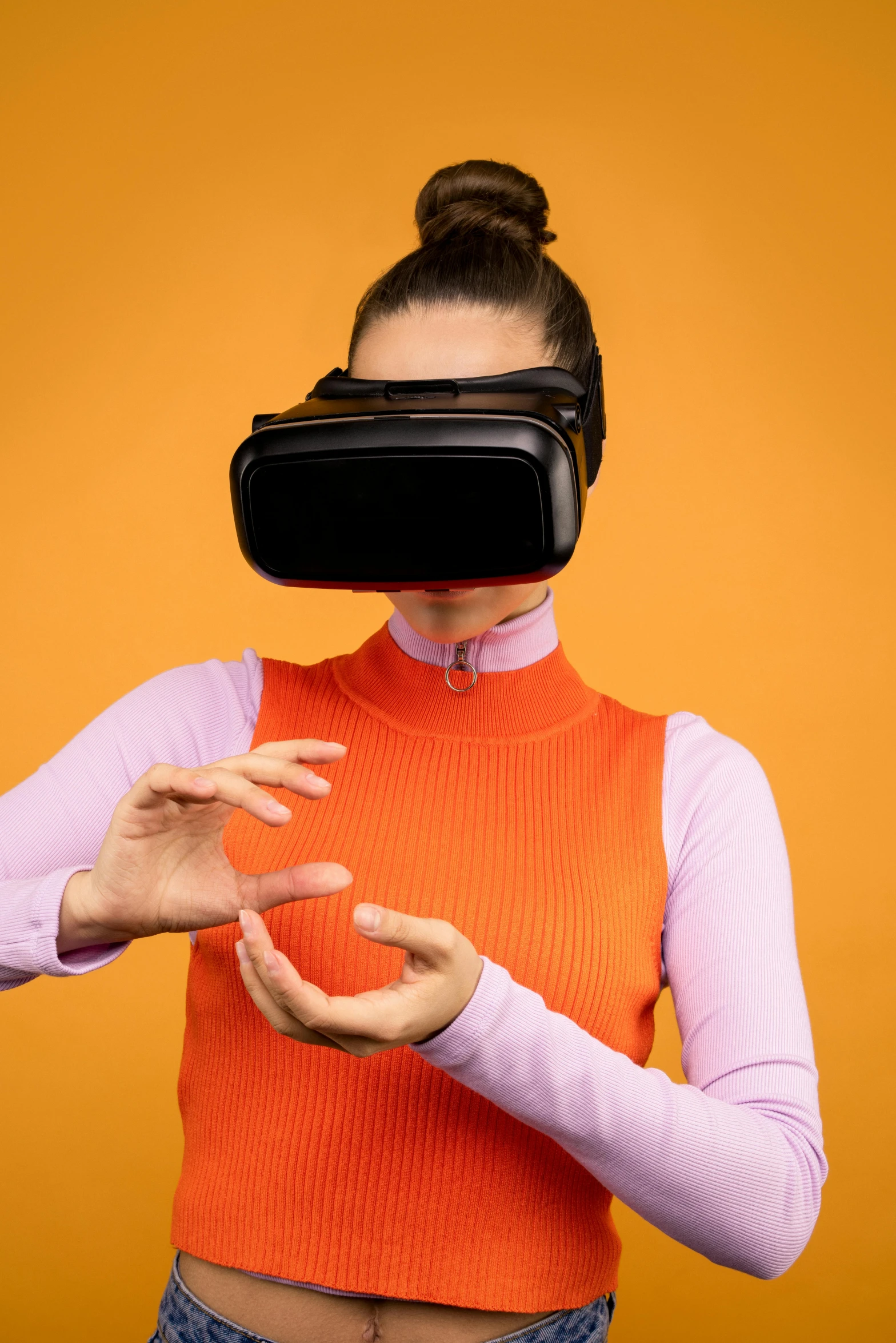 a woman wearing a virtual reality headset, by Adam Marczyński, shutterstock, hypermodernism, in front of an orange background, hand gesture, square, trending on mentalray