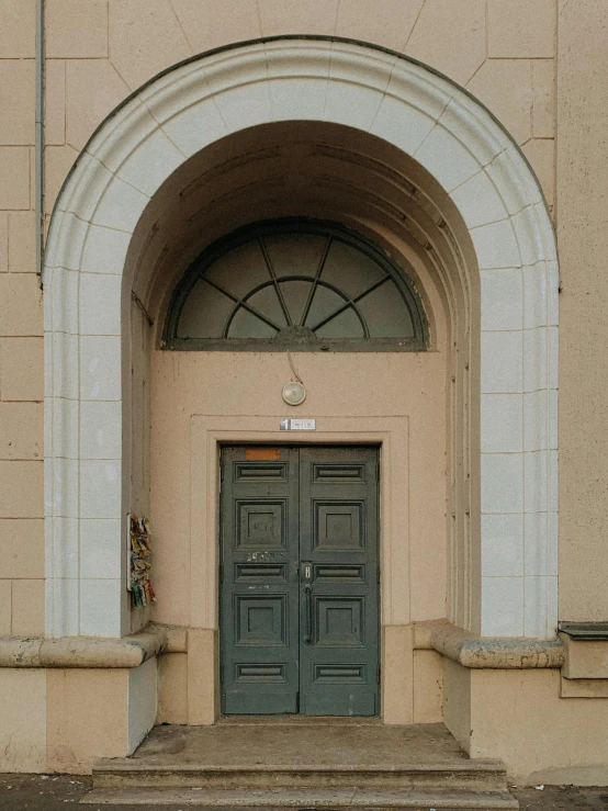 a yellow fire hydrant sitting in front of a green door, a photo, by Attila Meszlenyi, neoclassicism, massive arch, symmetrical doorway, brown, concrete building