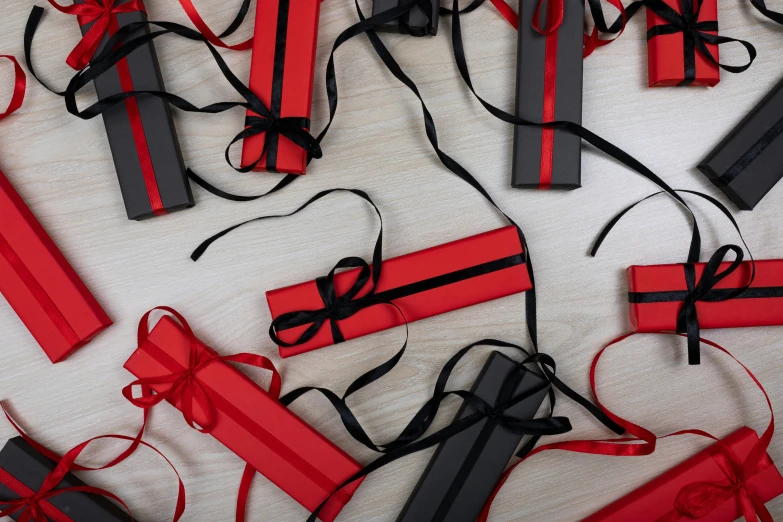 a bunch of red and black wrapped gifts on a table, by Eden Box, pexels contest winner, private press, ribbons, modelling, sleek spines, full product shot