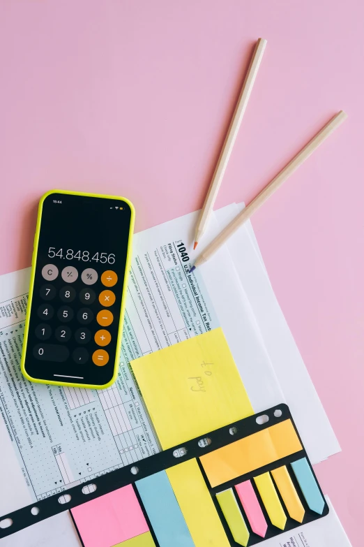 a cell phone sitting on top of a pile of papers, pink and yellow, math, thumbnail, tools