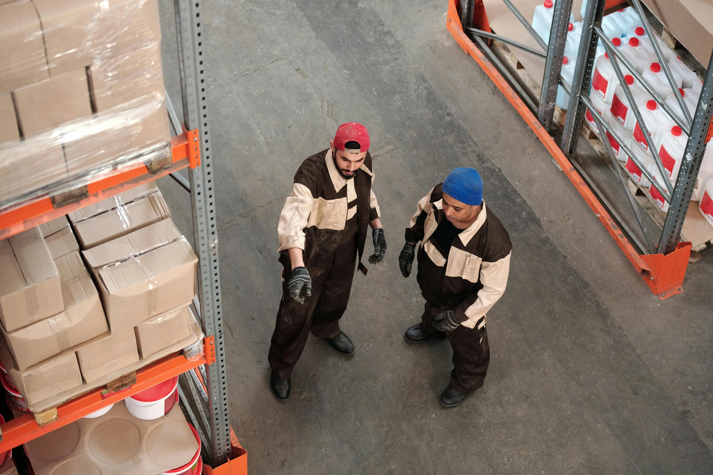 two men standing next to each other in a warehouse, pexels contest winner, costumes, birdseye view, avatar image, working clothes