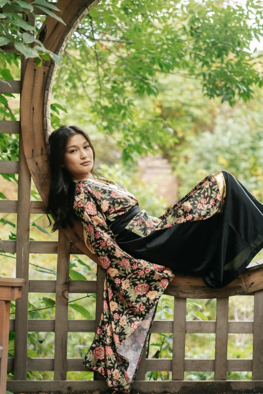 a woman sitting on top of a wooden bench, inspired by Li Di, unsplash, arabesque, wearing floral chiton, black, asian, bae suzy