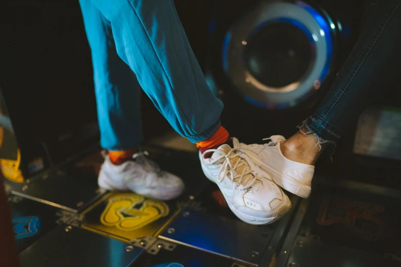 a person standing on top of a pinball machine, an album cover, trending on pexels, wearing white sneakers, dancing with each other, sitting on the floor, among us crewmate