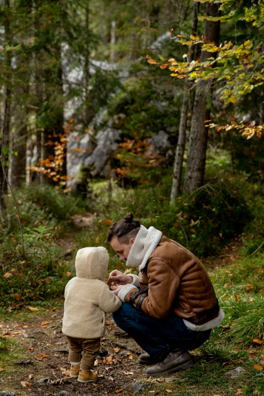 a woman and a child in the woods, by Jaakko Mattila, pexels contest winner, hugging his knees, father with child, thumbnail, autum