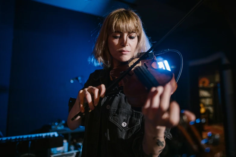 a woman playing a violin in a dark room, electric martina, lachlan bailey, beth cavener, profile image