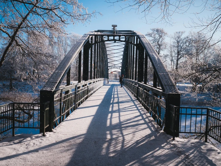 a bridge with snow on the ground and trees in the background, by Jacob Kainen, pexels contest winner, visual art, swedish urban landscape, on a sunny day, thumbnail, black