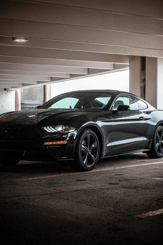 a black mustang parked in a parking garage, in 2 0 1 8, square, highly upvoted, slight overcast lighting