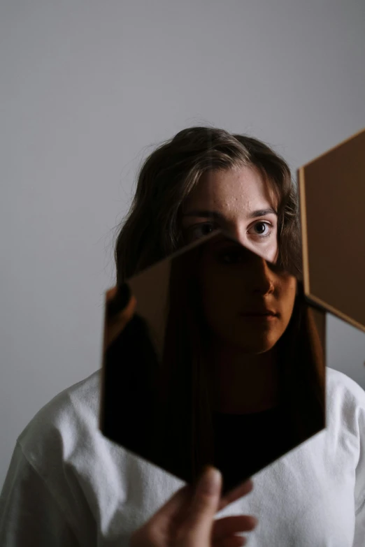 a woman holding a mirror in front of her face, an album cover, inspired by Anna Füssli, pokimane, high quality photo, tesseract, headshot