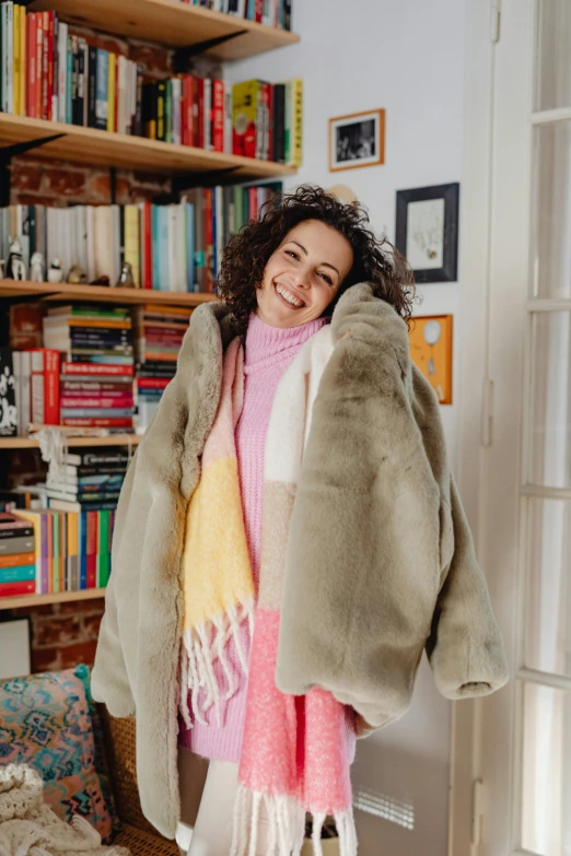 a woman standing in front of a bookshelf, featured on pinterest, happening, wearing a fur coat, rebecca sugar, covered with blanket, mina petrovic