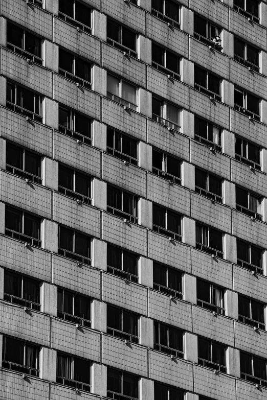 a black and white photo of a tall building, inspired by Andreas Gursky, unsplash, brutalism, house windows, square shapes, cubicles, little windows