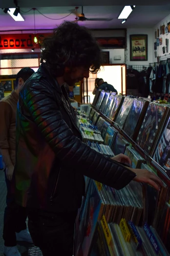 a man looking at records in a record store, an album cover, reddit, leather jackets, melbourne, phosphorescent, seen from the side