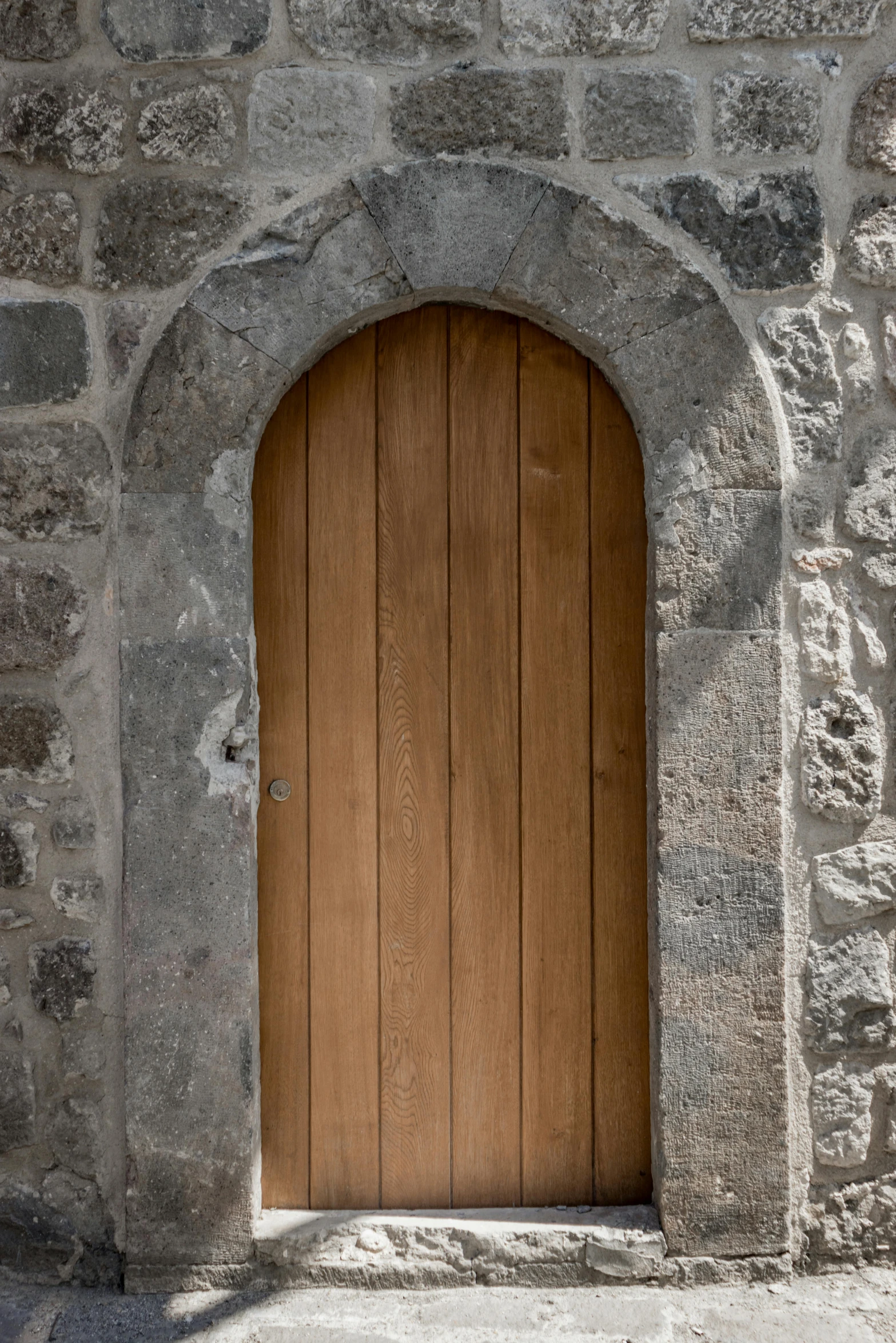 an old stone building with a wooden door, an album cover, unsplash, romanesque, reykjavik, full frame image, arched doorway, close-up photo