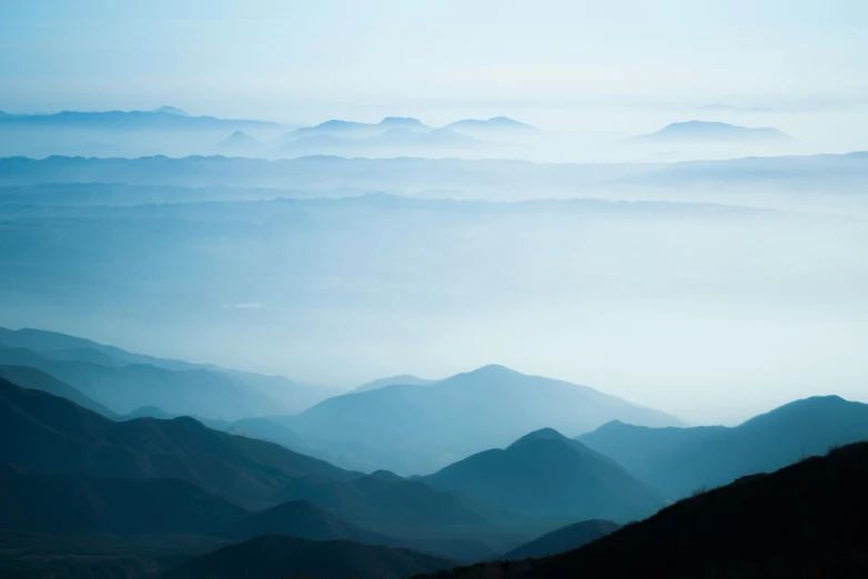 a view of the mountains from the top of a hill, unsplash contest winner, romanticism, subtle blue, multiple layers, murata range, hazy