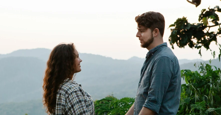 a man and a woman standing next to each other, mountainside, indie film, profile image, jungle in background