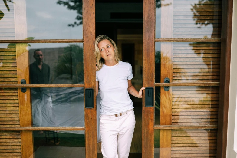 a woman standing in front of a wooden door, by Sara Saftleven, happening, wearing white shirt, alice hunt and peter hurd, slightly tanned, transparent background