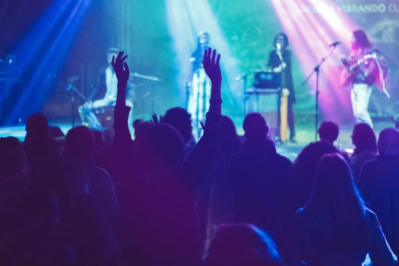 a group of people that are standing in front of a stage, pexels, happening, music being played, holy themed, blue, coloured