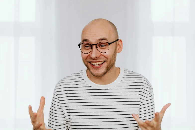 a man making a peace sign with his hands, a character portrait, inspired by Leo Leuppi, pexels contest winner, portrait of karl pilkington, jewish young man with glasses, laughing hysterically, portrait of bald
