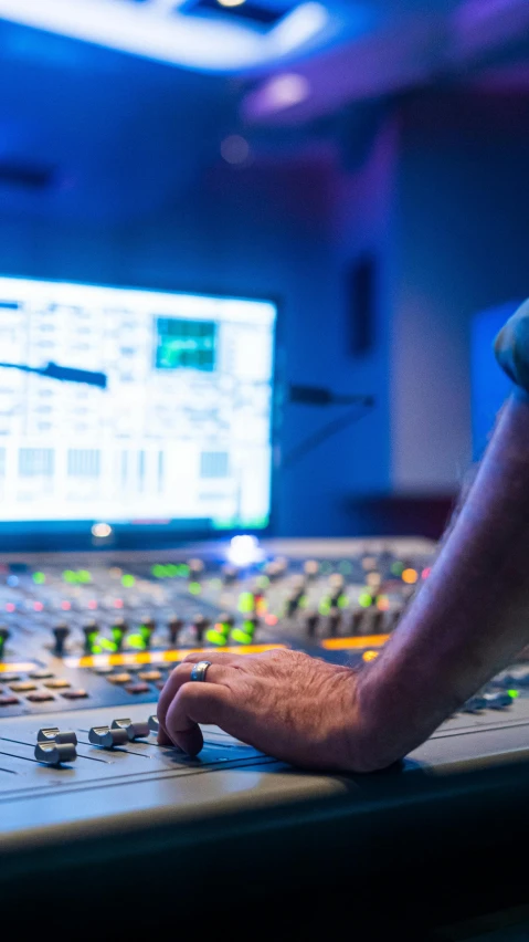 a man sitting at a mixing desk in front of a monitor, by Dan Content, pexels, process art, tv program, engineering, blue, radio