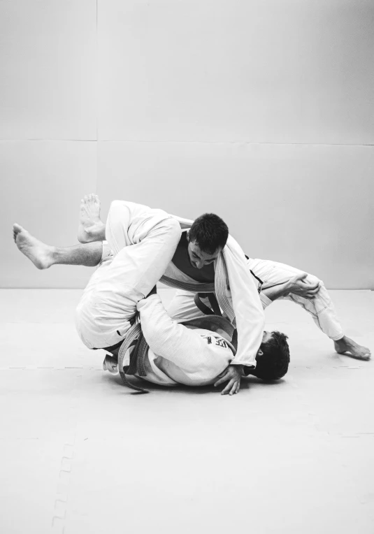 a couple of men standing next to each other on a floor, a black and white photo, unsplash, figuration libre, white belt, mid action swing, ffffound, piled around