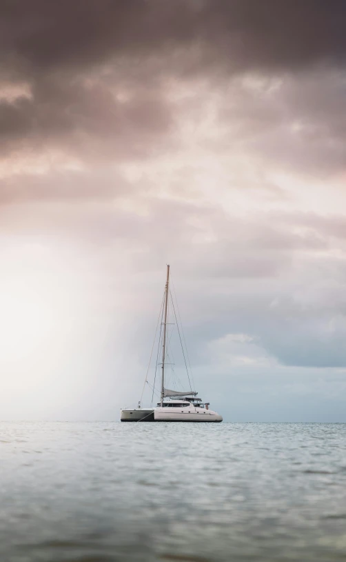 a boat floating on top of a body of water, by Peter Churcher, unsplash, on a yacht at sea, overcast skies, great barrier reef, kiss