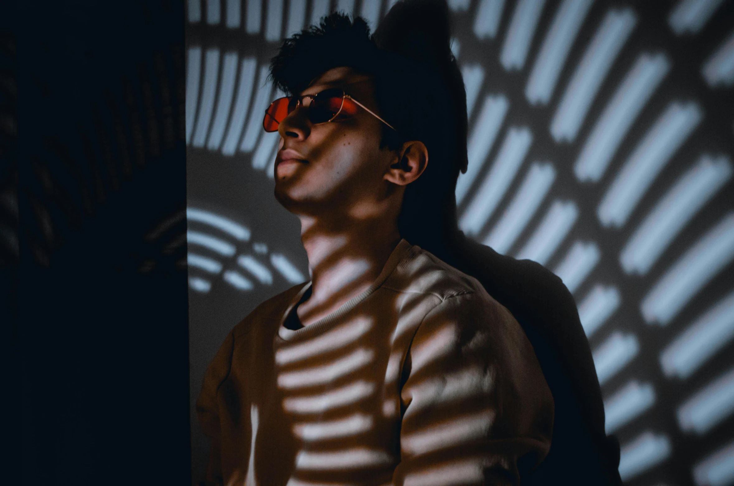 a man wearing sunglasses standing in front of a wall, pexels contest winner, bauhaus, dynamic lights and shadows, declan mckenna, **cinematic, ariel perez