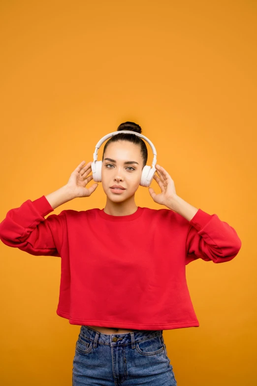 a woman with headphones covering her ears, trending on pexels, white and orange, wearing red and yellow clothes, symmetrical image, slightly minimal