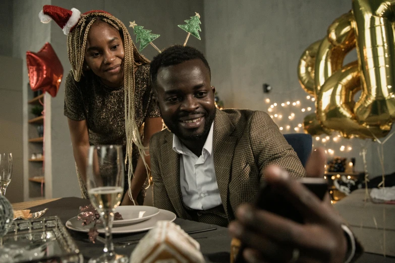 a man and a woman sitting at a table, pexels contest winner, happening, wearing festive clothing, kevin hart, mobile gimball camera, black people