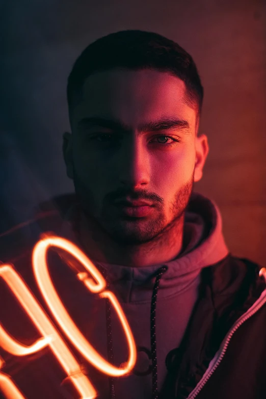 a man standing in front of a neon sign, trending on pexels, zayn malik, portrait soft light, arab, non binary model
