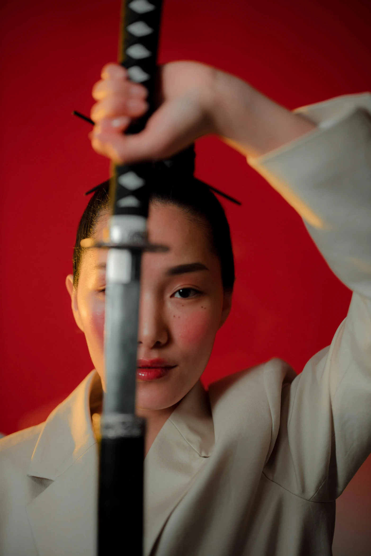 a woman holding a sword in front of her head, an album cover, inspired by Goyō Hashiguchi, unsplash, demna gvasalia, shot with sony alpha 1 camera, karate, headshot