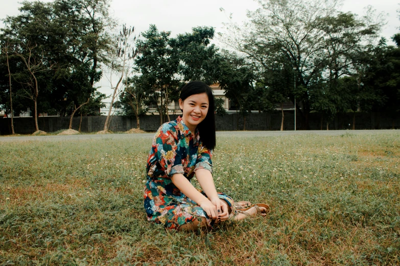 a woman sitting on top of a grass covered field, set on singaporean aesthetic, avatar image