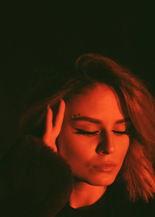 a woman with her eyes closed in the dark, an album cover, inspired by Elsa Bleda, trending on pexels, olivia culpo, square, cl, shy looking down