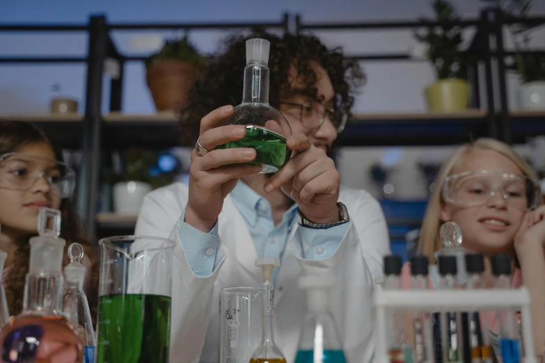 a man in a lab coat holding a green liquid, trending on pexels, avatar image, student, bong, woman