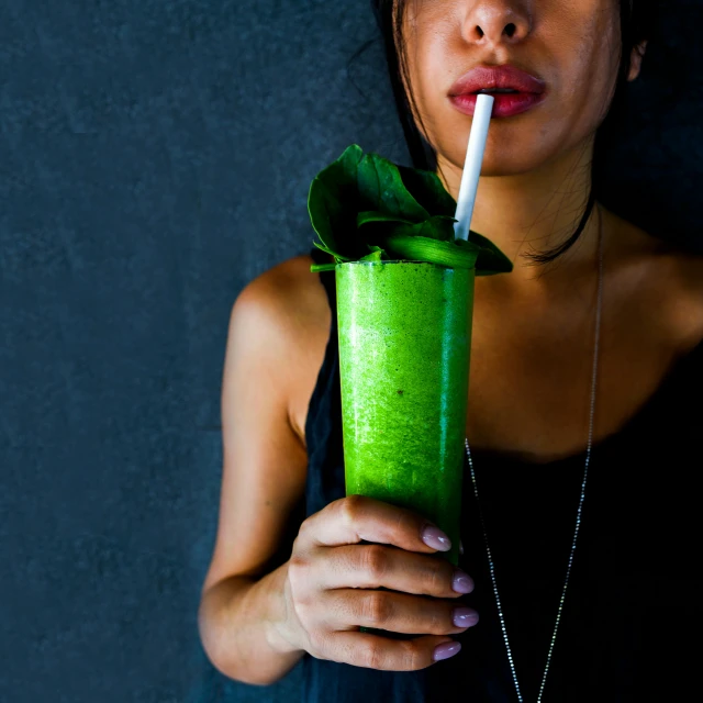 a woman holding a green drink with a straw, by Adam Marczyński, trending on pexels, renaissance, square, textured, an asian woman, 15081959 21121991 01012000 4k