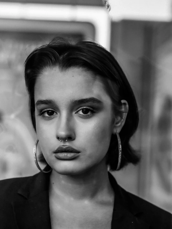 a black and white photo of a woman, a black and white photo, by Adam Marczyński, trending on pexels, realism, isabela moner, huge earrings and queer make up, portrait of kim petras, short slicked - back hair