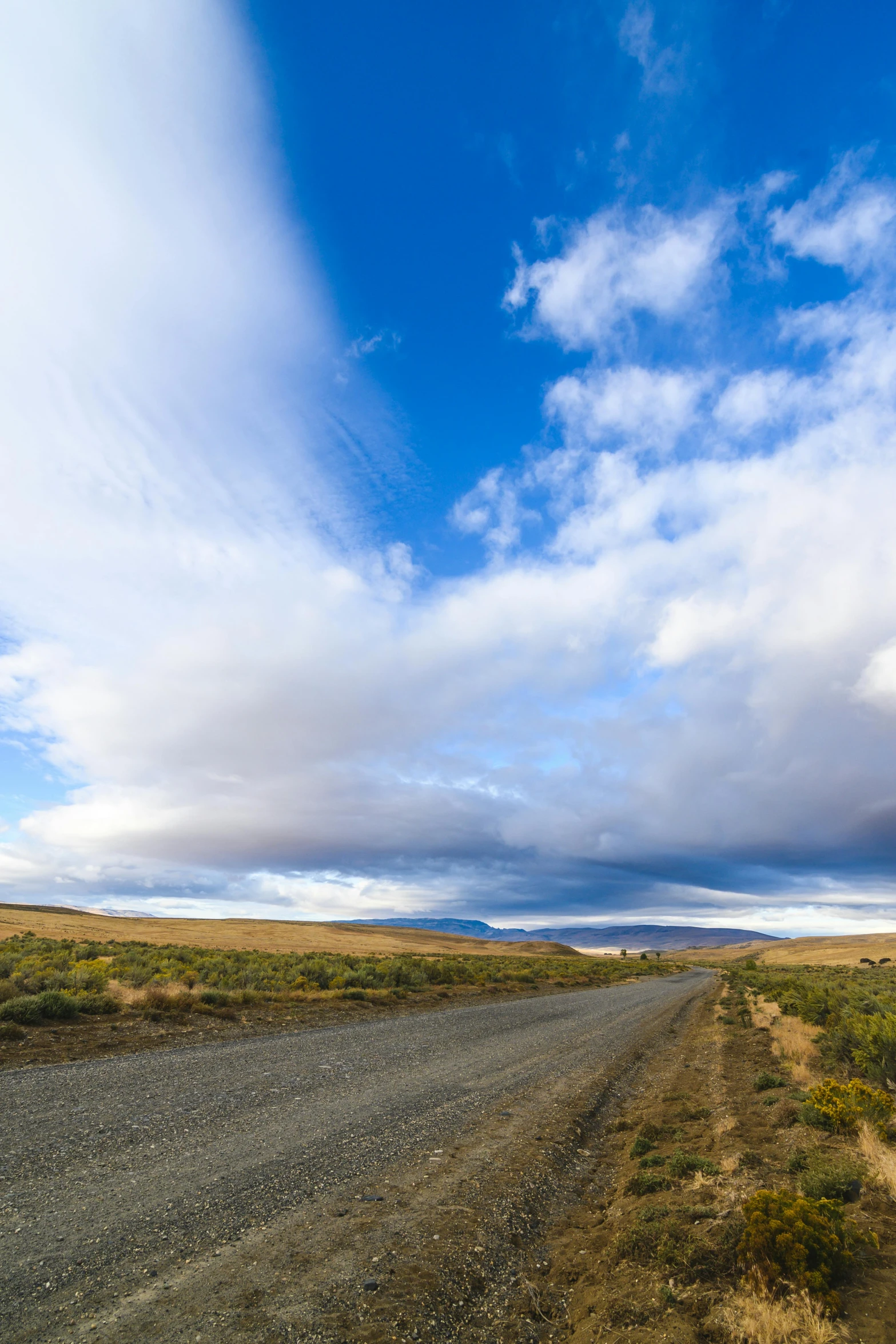 a dirt road in the middle of nowhere, by Peter Churcher, visual art, 4 k cinematic panoramic view, patagonian, soft clouds, today\'s featured photograph 4k