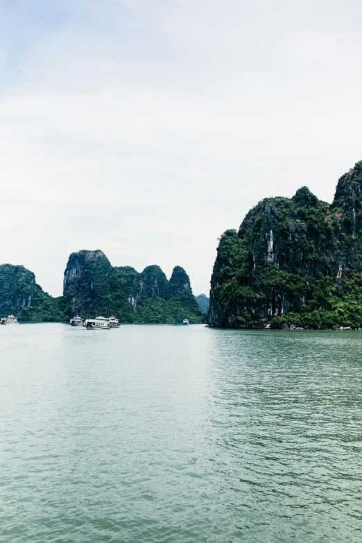 a large body of water with mountains in the background, a picture, vietnam, 8k resolution”, tall stone spires, portra 8 0 0 ”