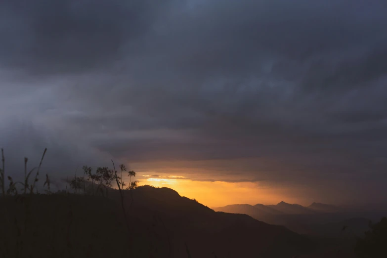 the sun is setting over the mountains on a cloudy day, by Peter Churcher, unsplash contest winner, australian tonalism, ((sunset)), big overcast, golden hour 8k, light and dark