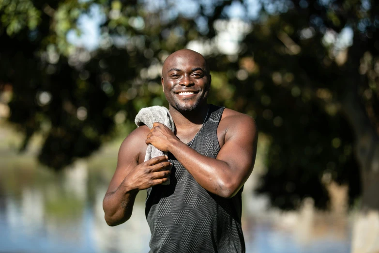 a man holding a bird in his arms, a portrait, by Julian Allen, pexels contest winner, happening, wearing fitness gear, brown skin man with a giant grin, sydney park, wearing a towel