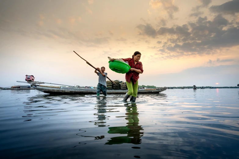 a group of people standing on top of a body of water, fishing village, lpoty, carrying a tray, canoe