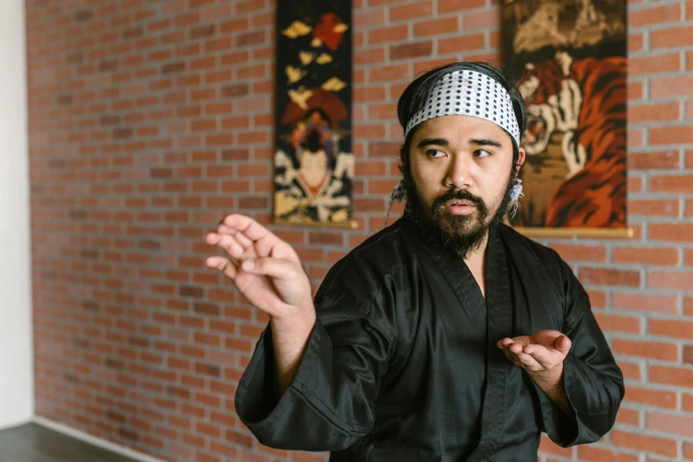 a man standing in front of a brick wall, a portrait, inspired by Kanō Shōsenin, in an action pose, wearing black robe, avatar image, david luong