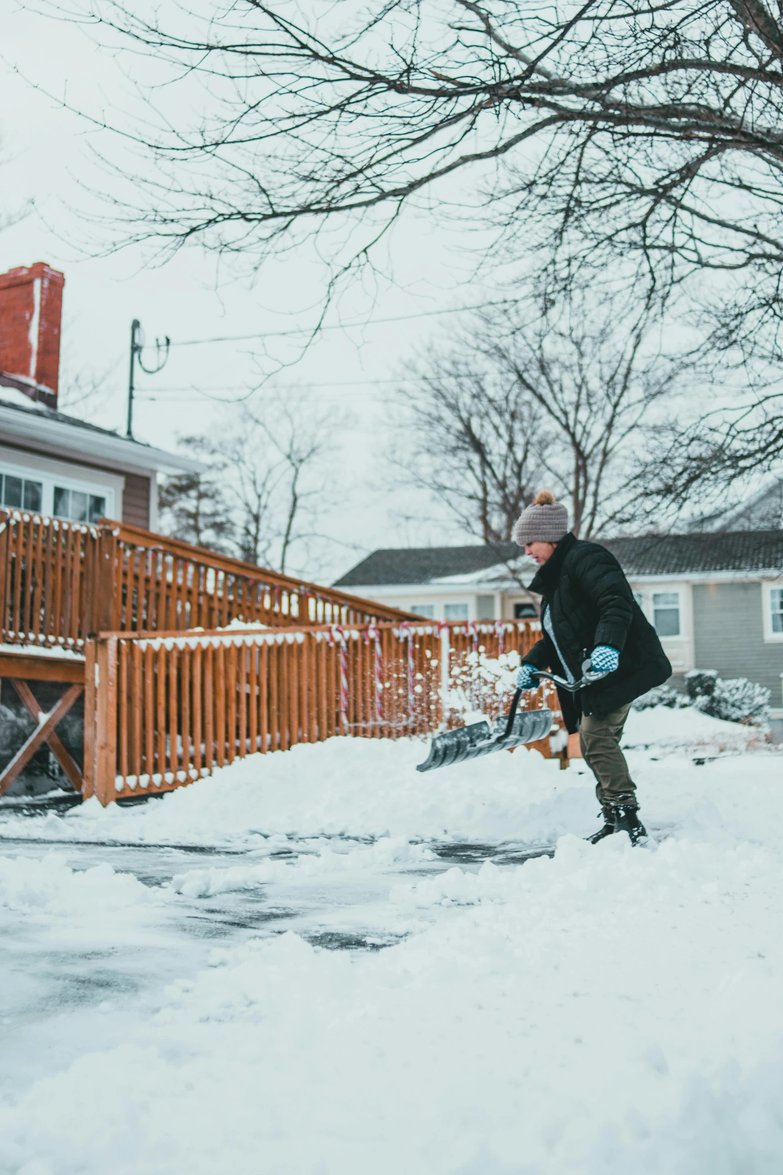 a man shoveling snow in front of a house, pexels contest winner, walking through a suburb, woman, brown, backwards