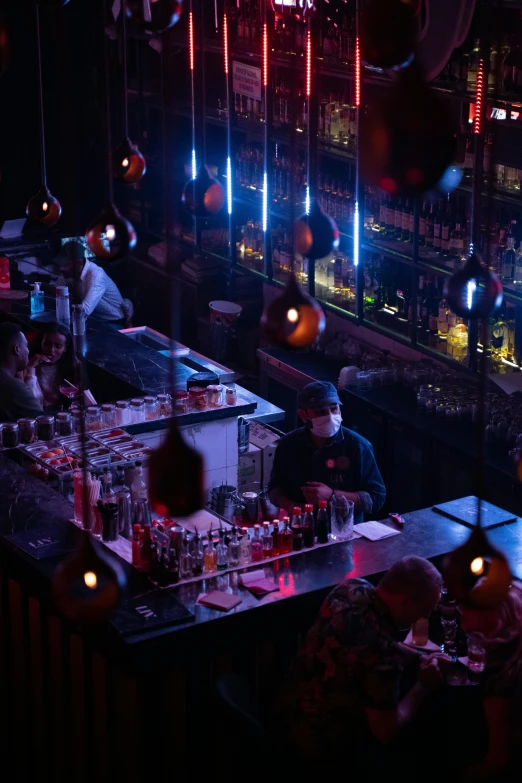 a group of people sitting at a bar, small red lights, dark deco, in chippendale sydney, mixing drinks