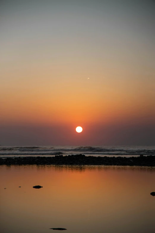 the sun is setting over a body of water, morocco, refracted moon on the ocean, in a sunset haze, lagoon