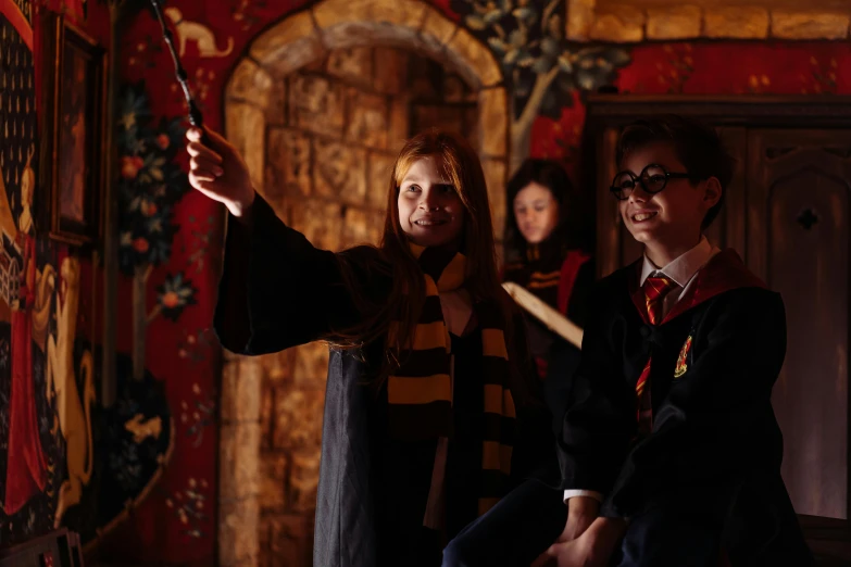 a group of people standing next to each other in a room, hogwarts gryffindor common room, immersive, profile image, performing